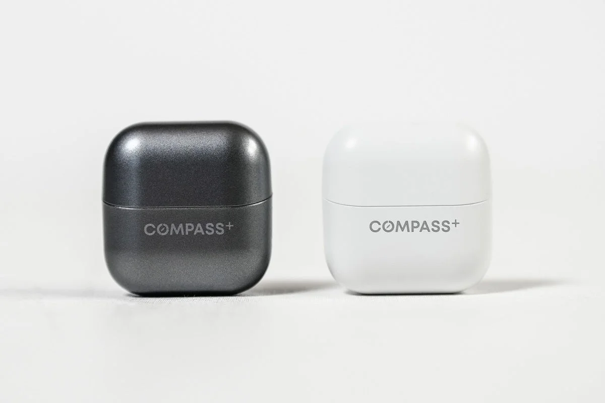 「COMPASS+」とロゴが印字された、黒と白の丸みを帯びた小型電子機器ケース
