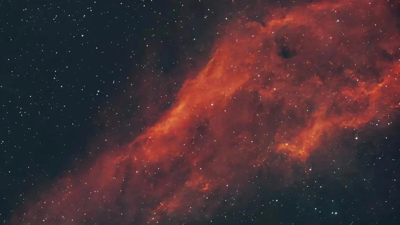 広大な宇宙空間に広がる赤く輝く星雲