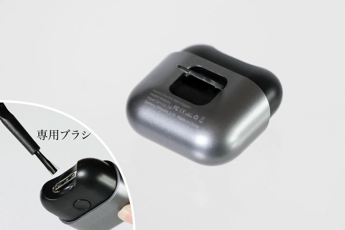 シルバーとブラックの電動爪切り本体と、付属の専用ブラシ
