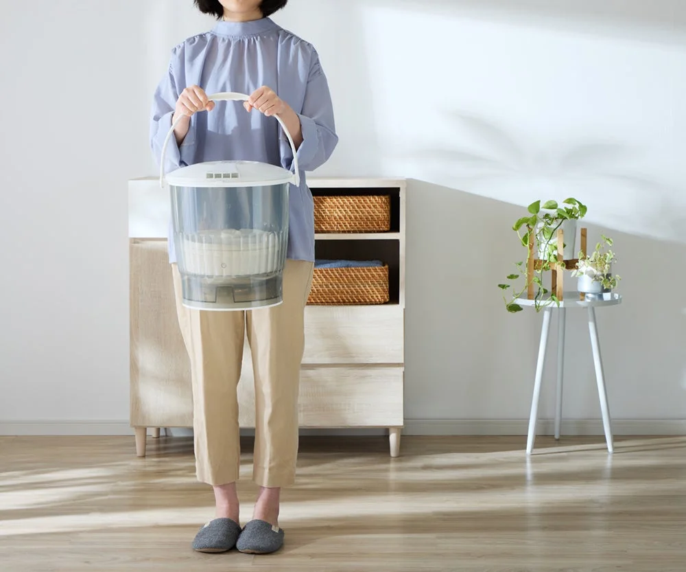 女性がポータブル洗濯機を手に持つ様子