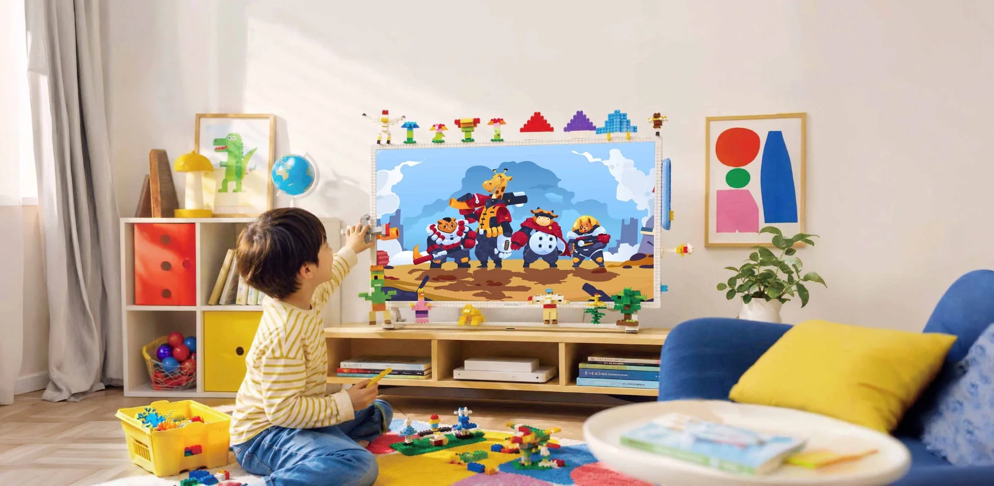 男の子がブロックでテレビを飾る様子