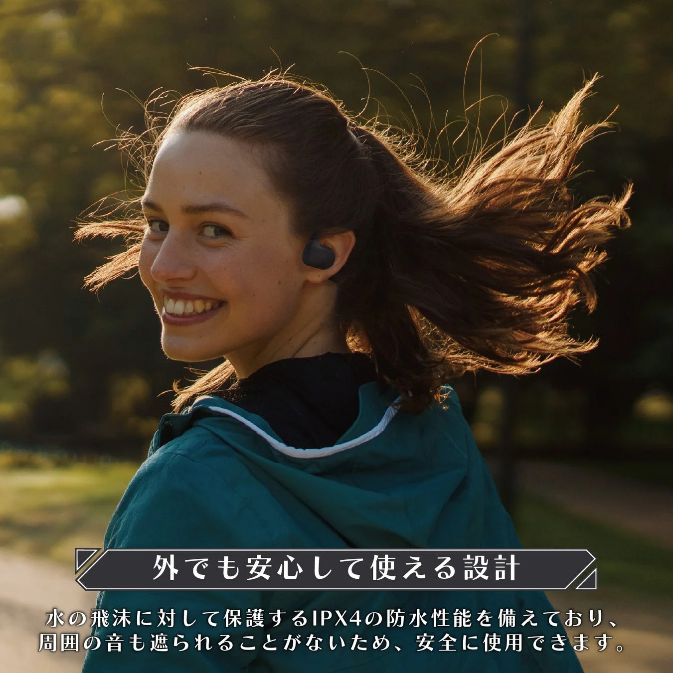 笑顔の女性がワイヤレスイヤホンを装着し、屋外で活動している