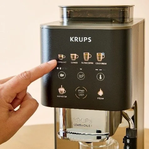 KRUPSのコーヒーメーカーのタッチパネルを指で操作している様子