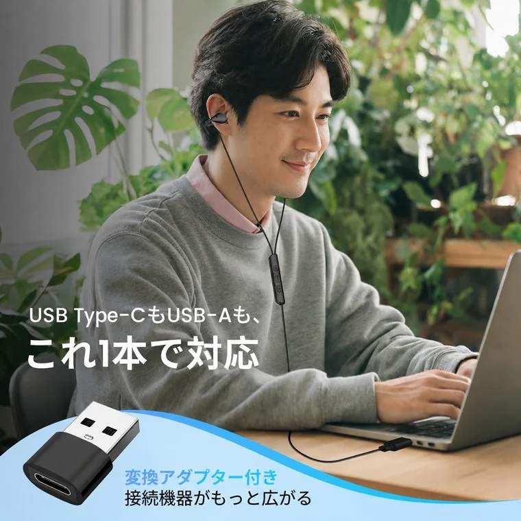 ノートパソコンを使用中の男性が有線イヤホンを装着