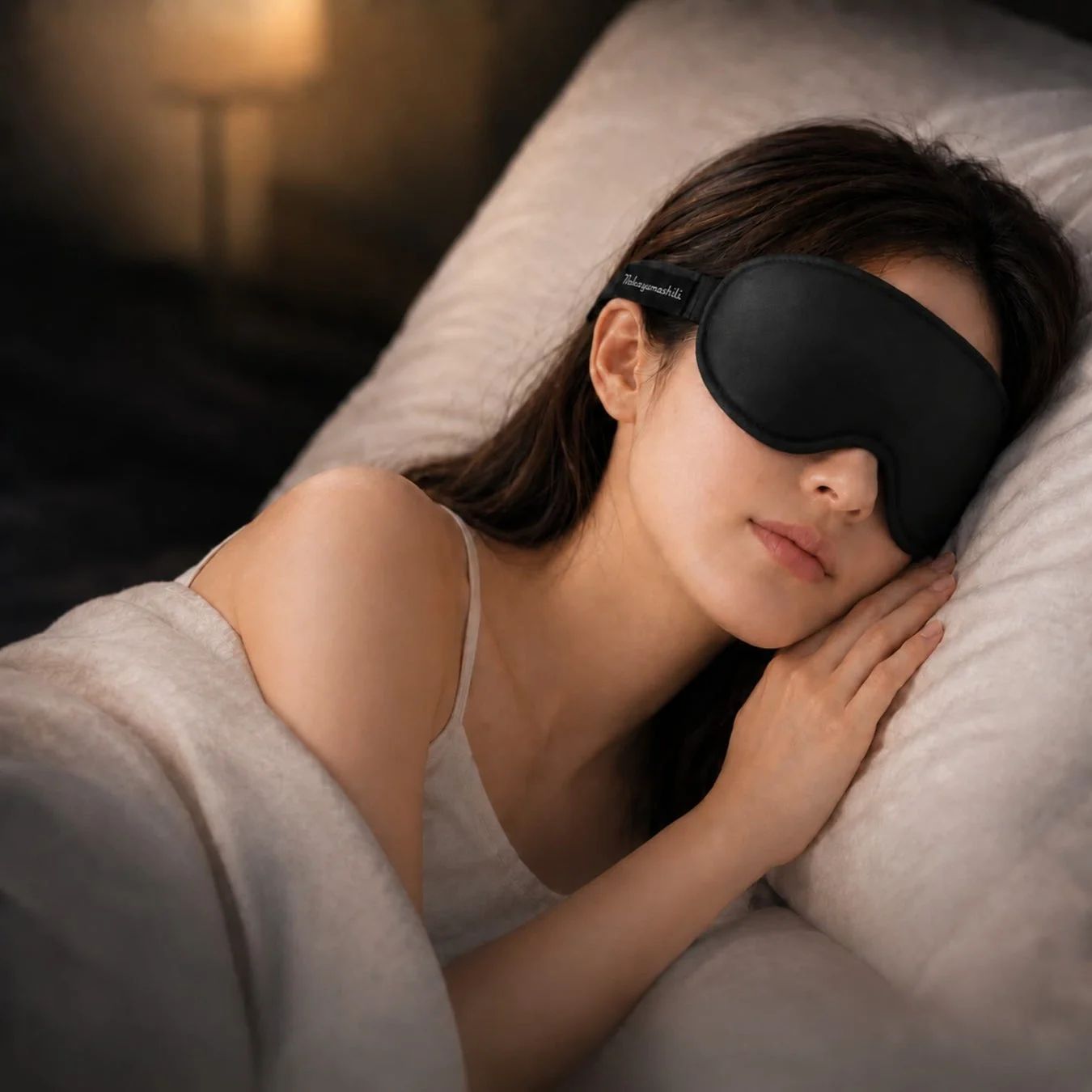 黒いアイマスクを着用した女性がベッドで安らかに眠っています。