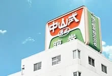 青空の下、白い建物の屋上に設置された大きな看板が写っています。