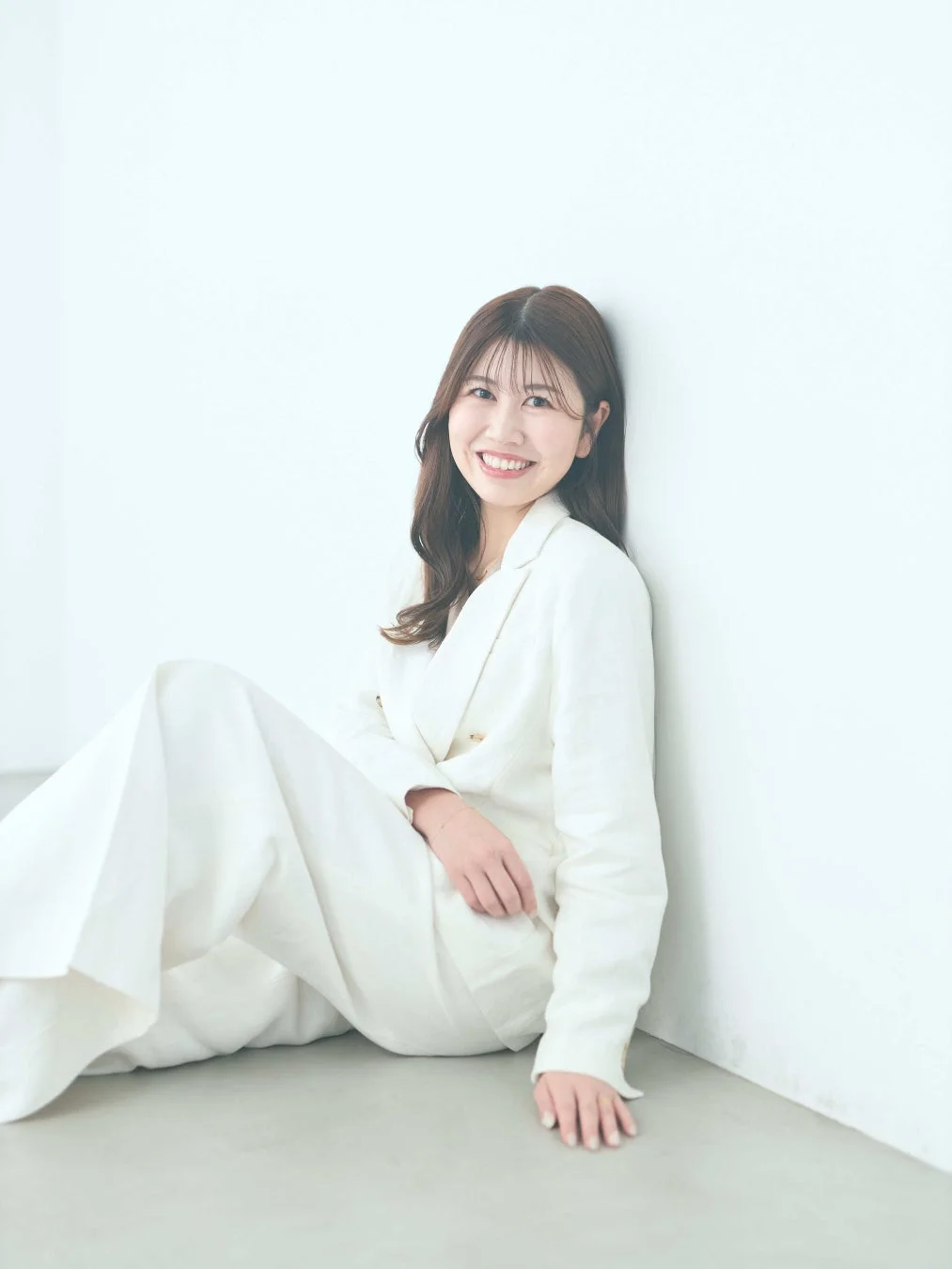 白いスーツを着て微笑む女性