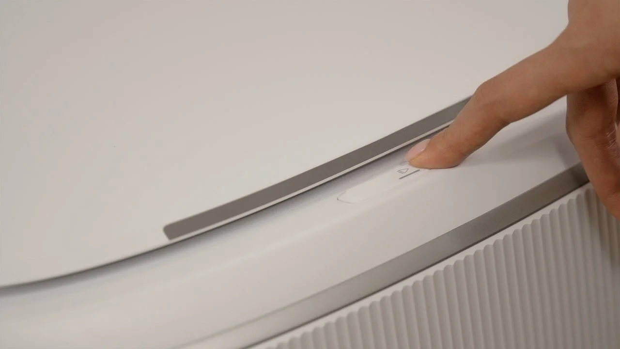 白い電子機器のボタンを指で押しているクローズアップ画像
