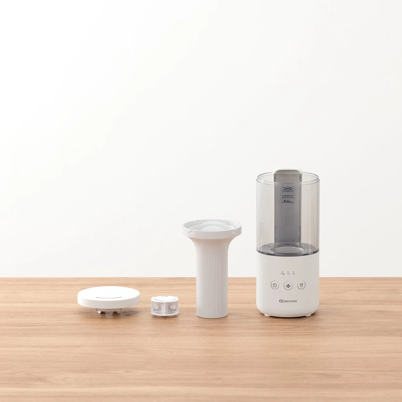 白いボディの加湿器が、その部品とともに木製のテーブルの上に並べられています