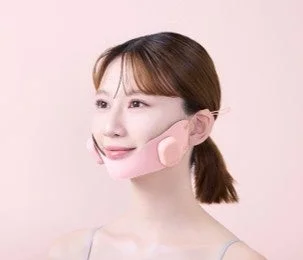 ピンク色の美顔器を装着した女性のクローズアップ画像です。