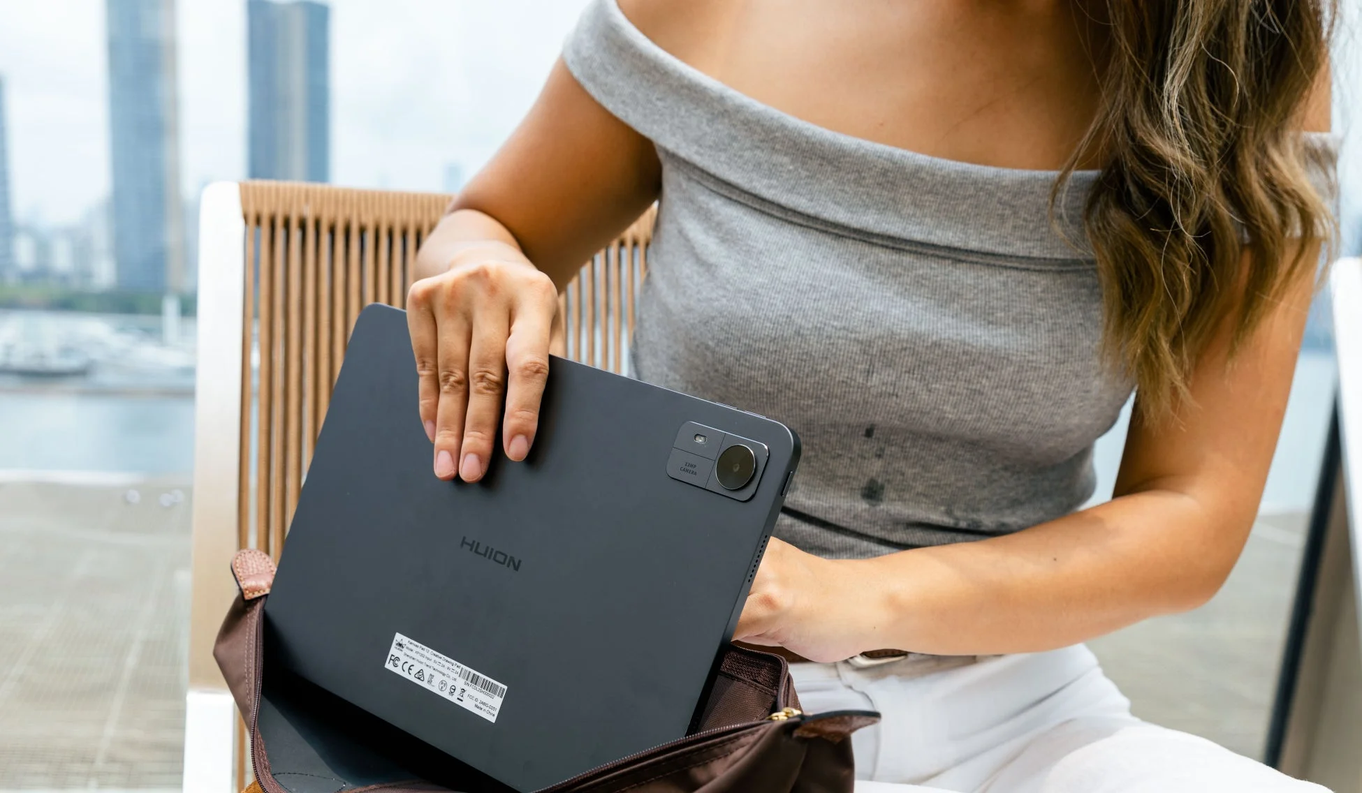 女性がタブレットをバッグに入れている様子